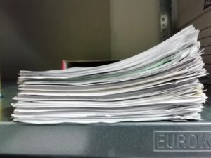 Liasse de papiers agrafés sur un coin.