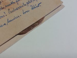 Deux feuilles de papier collées ensemble par un élastique qui a séché entre les deux.